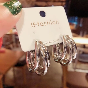 Three-layered silver irregular hoop earrings with 925 silver posts on a display card