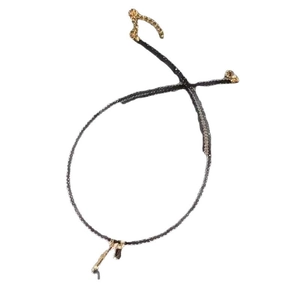 Minimalist black cord tassel necklace with gold accents shown on a plain white background