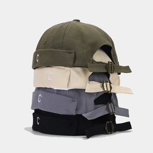 Dettaglio di quattro colori di cappelli docker con ricamo C e fibbie in metallo regolabili