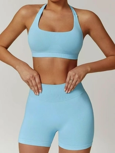 Detail of light blue high-waist ribbed yoga shorts and racerback sports bra set