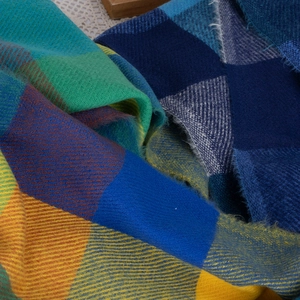 Detailed macro view of colorful plaid cashmere scarf with thick twill texture and fringe