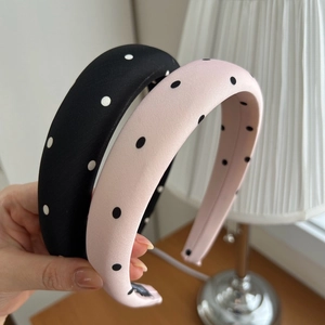 Detail shot of wide sponge headbands with satin polka dot pattern in black and pink