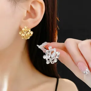 Floral cluster stud earrings in gold and silver finish with textured metal petals
