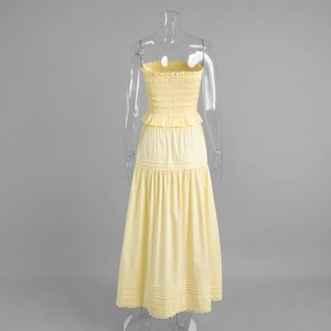 Detail view of the smocked bodice and elegant pintuck pleats on this yellow A-line dress