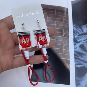 Detailed view of creative blood bag earrings with AB type blood group label in Y2K style