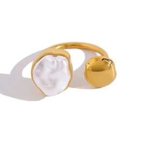 Close-up of golden irregular baroque pearl ring with polished metallic spherical detail