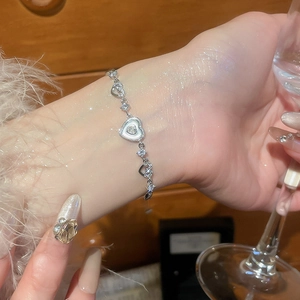 Detail of silver heart bracelet with white mother of pearl and cubic zirconia stones