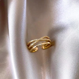 Macro detail of rose gold double-layer crisscross ring with pavé cubic zirconia