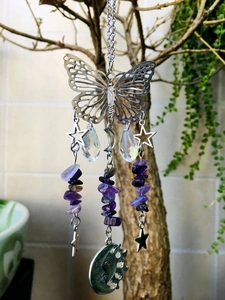 Detail of silver butterfly suncatcher with amethyst stones and crystal prisms hanging