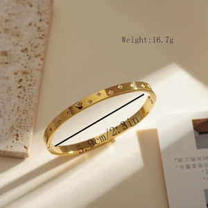 Detail showing a 5.9cm inner diameter and 16.7g weight of the gold star engraved bracelet
