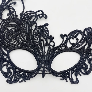 Close-up of black lace phoenix eye mask with intricate hollow patterns for masquerade