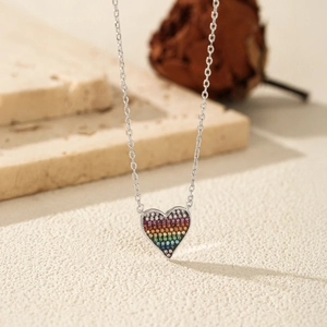 Collana cuore in argento S925 con zirconi colorati arcobaleno su sfondo di pietra bianca