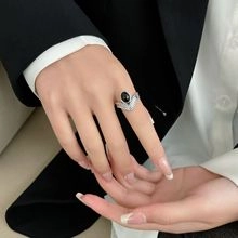 Dettaglio anello vintage in argento S925 con pietra nera su mano di donna