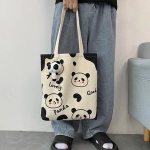 Detail der Panda-Stofftasche mit Cartoon-Mustern und einem 3D-Plüsch-Panda-Anhänger