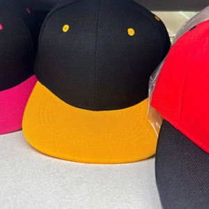 Detail of color-block snapback baseball cap in black and yellow with twill cotton texture