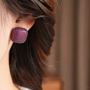 Vue macro de boucles d'oreilles vintage carrées avec zircons violets sur mannequin