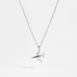 Macro shot of minimalist S925 sterling silver airplane pendant on a delicate chain