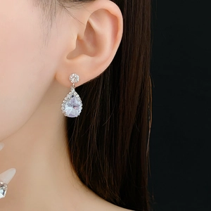 Gros plan de boucles d'oreilles gouttes en argent avec zircons portées par un mannequin