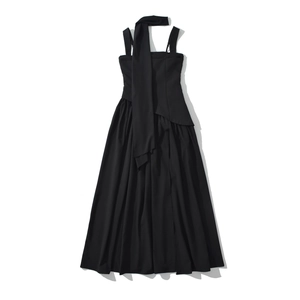 Dettaglio di elegante abito nero senza spalline con sciarpa lunga e gonna a pieghe