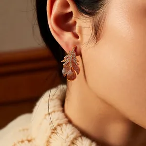 Elegant 18k gold plated feather earrings set with shimmering cubic zirconia stones