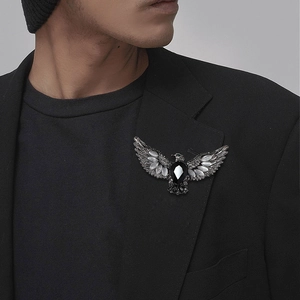 Vintage eagle brooch with black teardrop gem on a black suit lapel for a gothic style