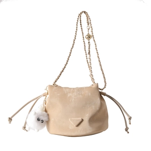Sac seau beige à cordon avec bandoulière chaîne dorée et charm pompon duveteux