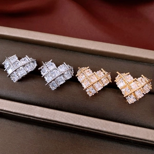 Detailed view of 18k gold and silver heart stud earrings with cubic zirconia inlay
