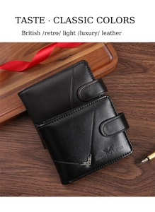 Close-up of vintage black leather men's wallet with metal V-buckle on a wooden tray