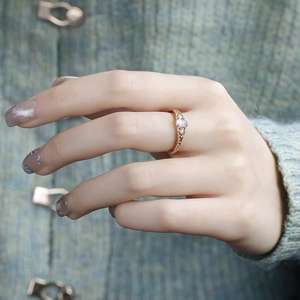 Close-up of retro pear-shaped gemstone ring with rose gold openwork and accent diamonds