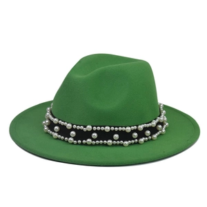 Detail of sage green wide brim fedora hat with elegant pearl embellished black band