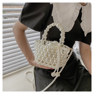 Détail du tissage de perles et de la doublure en satin avec cordon de ce mini sac seau