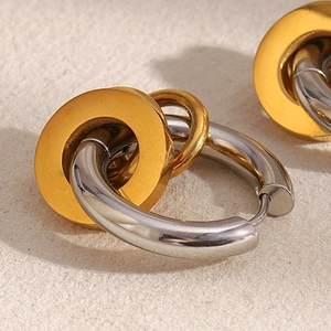 Gros plan de boucles d'oreilles créoles triples géométriques en acier doré 18K et argenté