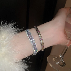 Makroaufnahme von mehrlagigem Silberarmband mit Strass und rosa Kristalledelsteinen