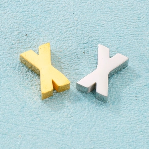Détail de pendentifs en forme de X dorés et argentés pour la création de bijoux DIY