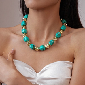 Close-up of bohemian beaded necklace with turquoise acrylic stones and golden metal beads