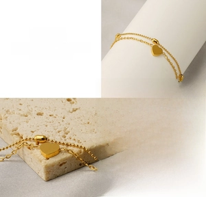 Detail of 18K gold-plated double-layer heart anklet showing the polished steel finish