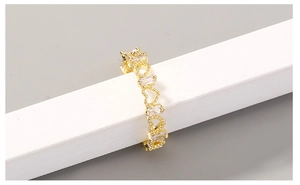 Detailed view of adjustable gold ring with heart patterns and clear zircon stones