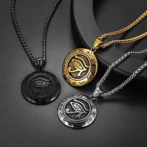 Detail of Eye of Horus pendants in black, gold, and silver finish on wheat chains