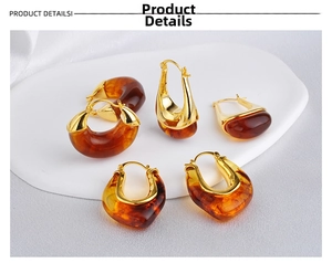Detailed close-up of Maillard amber resin and gold U-shaped hoop earrings on display