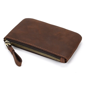 Detail of crazy horse leather coin purse with brass zipper and visible stitching texture