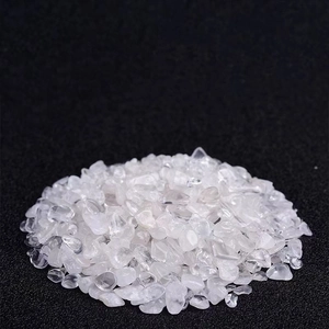 Macro shot of natural clear quartz tumbled stones on a black textured background
