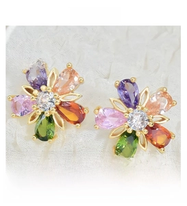Close-up of five-petal flower studs with colorful zircons and golden alloy base