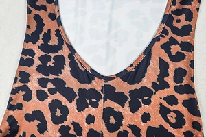 Detail of deep U-neckline and leopard print pattern on elastic slim jumpsuit