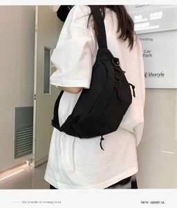 Detail of durable black nylon crossbody chest bag with multiple zipper pockets and straps