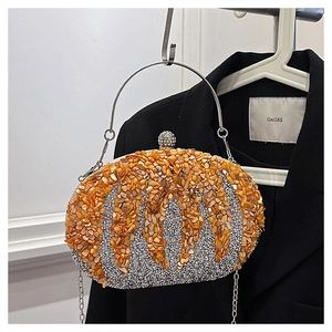 Close-up of orange rhinestone dinner bag with silver glitter and metal chain strap