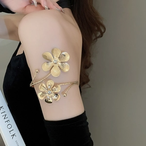 Detailed view of adjustable gold flower arm cuff featuring sparkling crystals on large petals