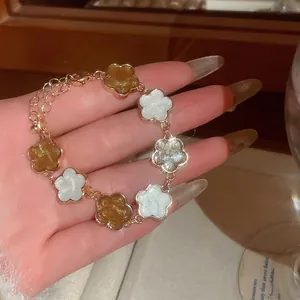 Bracelet vintage doré avec des fleurs émaillées blanches et ambrées pour femme