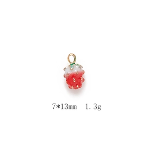Detailed macro of a red strawberry alloy pendant with gold accents measuring 7x13mm