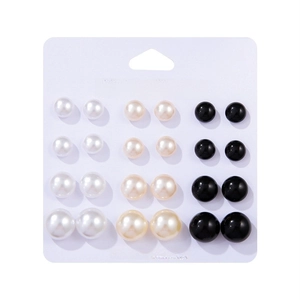 Detail view of 12 pairs of multi-sized faux pearl stud earrings in white, beige, and black