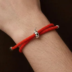 Minimalist red woven lucky bracelet with s925 silver apple charm on a model wrist